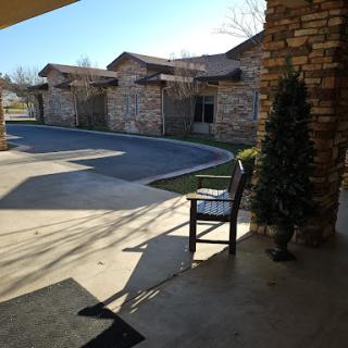 A serene outdoor view featuring a chair and well-maintained buildings under bright sunlight.