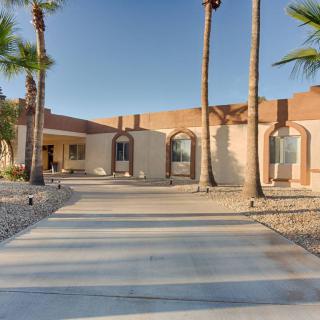 A modern desert home with palm trees and a spacious driveway.