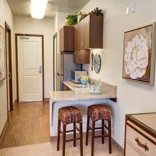 A cozy apartment kitchen with bar stools and modern decor.