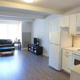 A modern open-space apartment with a kitchen, living area, and furniture.