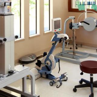 A physical therapy room equipped with various rehabilitation machines and exercise equipment.