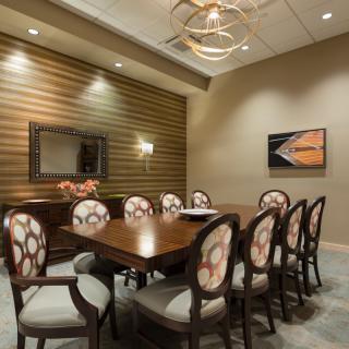 A modern conference room with elegant decor and a central meeting table surrounded by chairs.