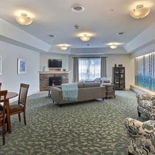A cozy living room with sofas, a fireplace, and a television.