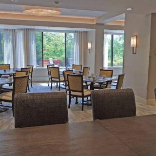A well-lit dining area with multiple tables and chairs, showcasing a modern interior.