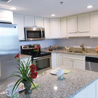 A modern kitchen with granite countertops and stainless steel appliances.