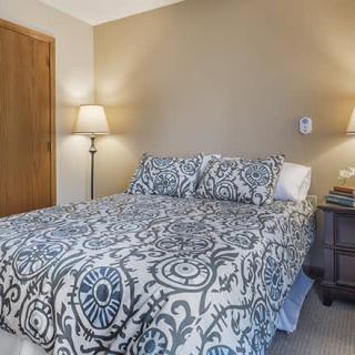 A cozy bedroom with patterned bedding and warm lighting.