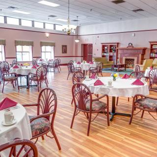 A spacious dining room with neatly arranged tables and chairs, featuring a warm and inviting decor.