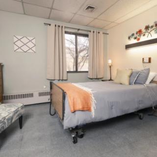 A cozy bedroom with a bed, decorative pillows, and a window letting in natural light.