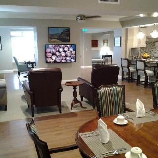 A spacious living and dining area featuring a television, comfortable seating, and an open kitchen.