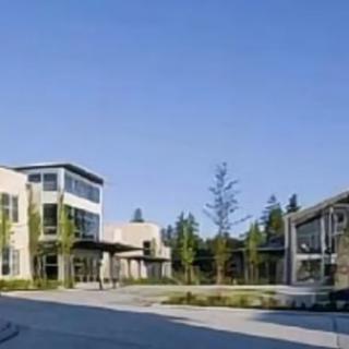 A modern school campus with contemporary architecture and surrounding trees.