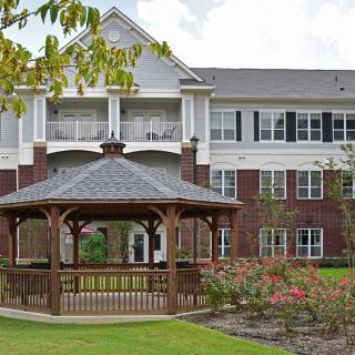 A residential building with a gazebo and well-maintained garden area.