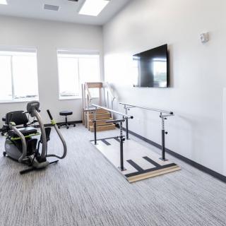 A clean and well-equipped physical therapy room with exercise equipment and training tools.