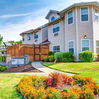 A beautifully landscaped house with vibrant flowers and well-maintained greenery.