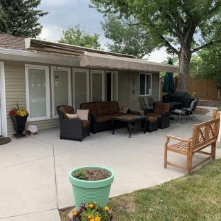 A cozy patio with outdoor seating and potted plants in a backyard setting.