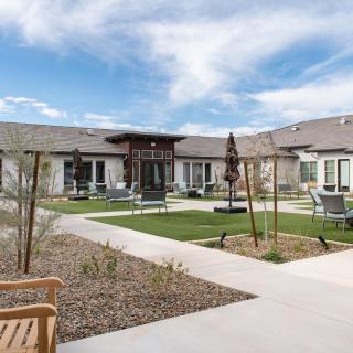 A landscaped courtyard with seating areas surrounded by a single-story building.