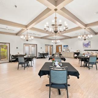 A spacious and elegantly designed dining area featuring modern furniture and ambient lighting.
