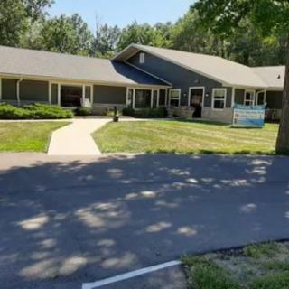 A residential building with a well-maintained yard and a paved pathway leading to the entrance.