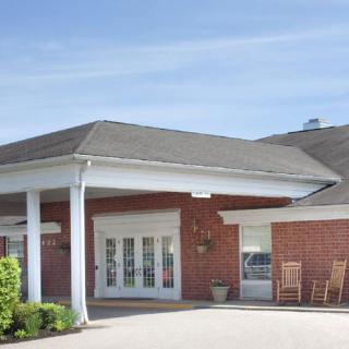 A brick building with a covered entrance and white columns.