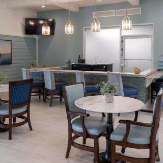 A modern restaurant interior with neatly arranged tables and chairs, featuring stylish lighting and decor.