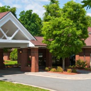 A welcoming brick building entrance with surrounding greenery.