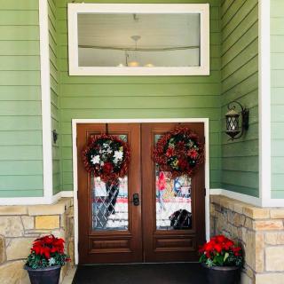 A festive front entrance decorated with wreaths and poinsettias.