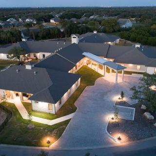 Aerial view of a large building complex illuminated at night.