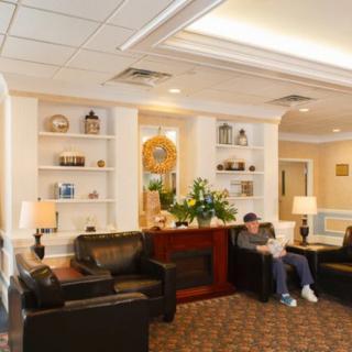 A cozy lobby with comfortable seating and decorative shelves.