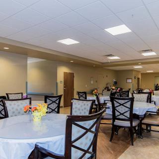 A well-lit dining area with tables and chairs arranged neatly.