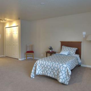 A minimalist bedroom with a single bed and neutral color scheme.