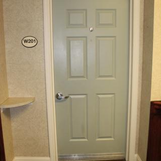 A closed hotel room door with the number 1003.