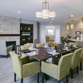 A modern dining area with a fireplace, featuring stylish furniture and elegant lighting.