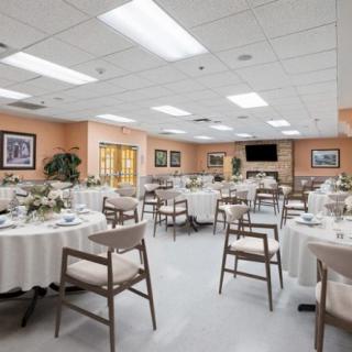 A well-decorated dining area with neatly arranged tables and chairs, perfect for a banquet or special event.
