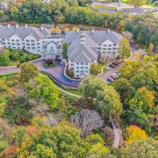 A serene aerial view of a hotel nestled among vibrant autumn foliage.