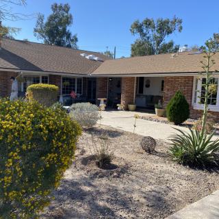A residential house with a landscaped front yard under a sunny sky.