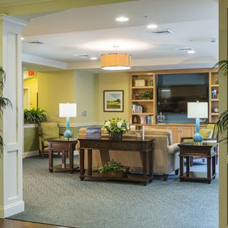 A cozy living room with comfortable seating, lamps, and a bookshelf.