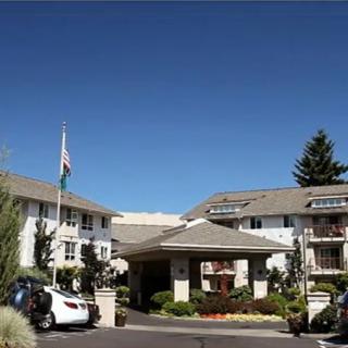 A residential apartment complex with parked cars and a clear blue sky.