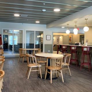 A modern cafe interior with tables, chairs, and a bar counter.