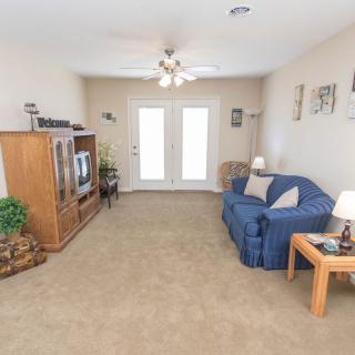 A cozy living room with a blue sofa, wooden furniture, and a television.