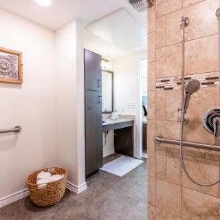 A modern bathroom featuring a stylish shower, vanity area, and neatly arranged towels.