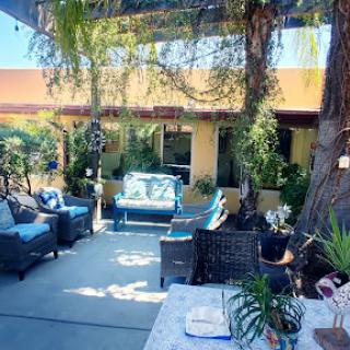 A serene outdoor patio space surrounded by greenery, perfect for relaxation and enjoying sunny days.