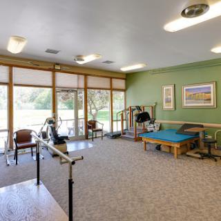 A bright and spacious rehabilitation therapy room equipped with various exercise tools.