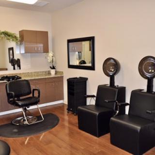 A modern hair salon interior featuring styling chairs and hairdryers.