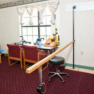 A therapy room with parallel bars and office furniture.