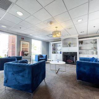 A modern lounge area featuring stylish blue sofas and a contemporary coffee table, perfect for relaxation.