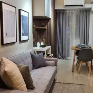 A modern living room with a stylish sofa, wall art, and a dining area.