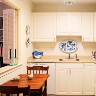 A cozy kitchen with a small dining area and classic white cabinets.
