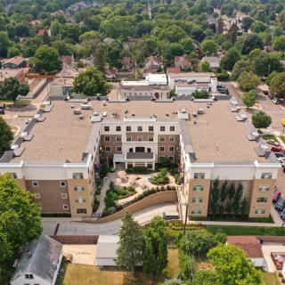 Aerial view of a large building surrounded by trees in a residential area.