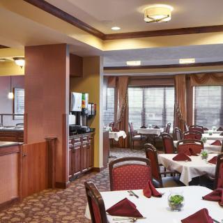 A well-appointed restaurant dining area with neatly arranged tables and chairs.