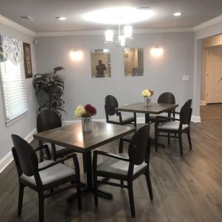 A modern dining area with neatly arranged tables and chairs, featuring elegant decor and lighting.