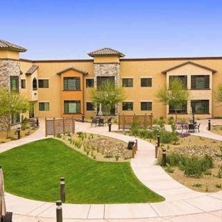 A modern building with a landscaped courtyard featuring grassy areas and pathways.